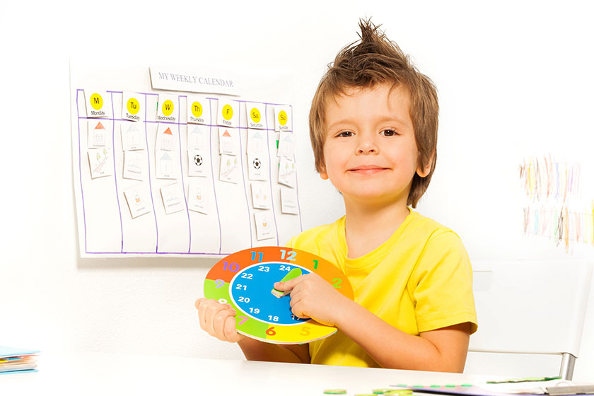 Boy holding colorful carton clock