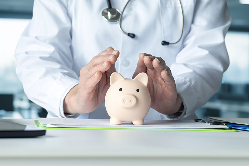 The doctor protects the piggy bank with a gesture