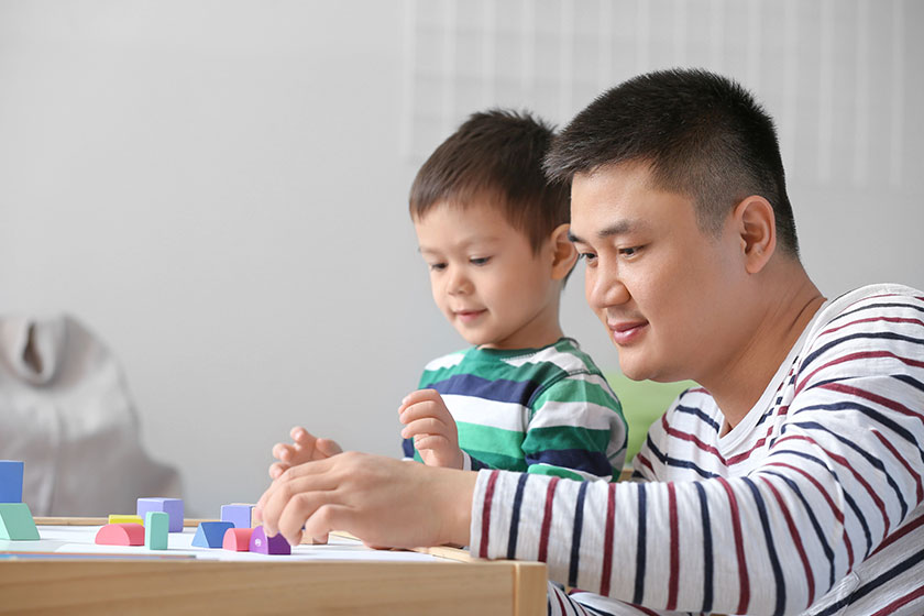 Happy father and his little son playing at home