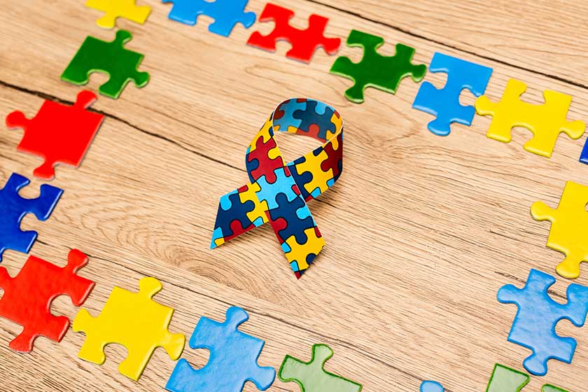 High angle view of awareness ribbon with pieces of puzzle