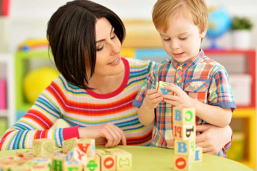 Woman and little boy playing with cubes